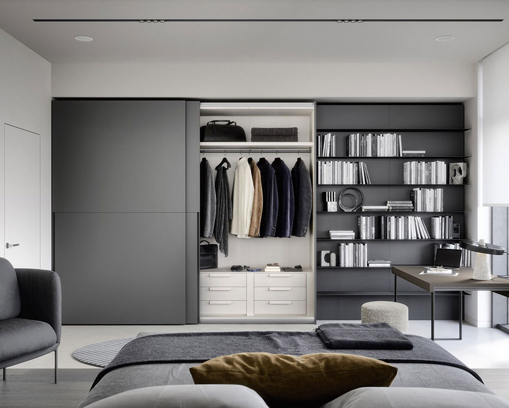 Armadio moderno a muro con ante scorrevoli, ripiani pieni di libri e abbigliamento organizzato in modo elegante, in un ambiente minimalista.